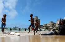Crianças brincam em Mogadíscio, Somlia, na rebentação do oceano Índico