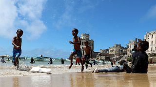 Crianças brincam em Mogadíscio, Somlia, na rebentação do oceano Índico