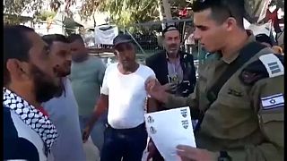 ضابط إسرائيلي يسلم إخطارات بهدم بيوت قرية خان الأحمر بأيدي أصحابها