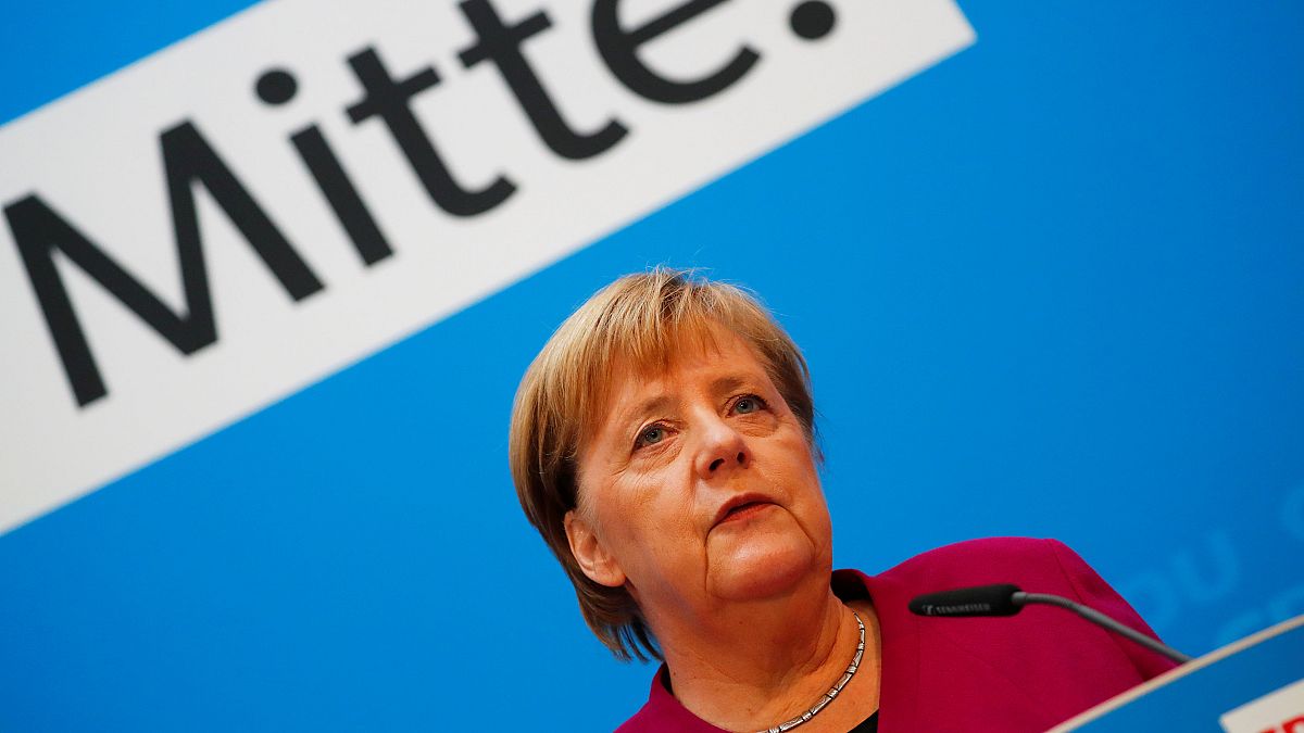 Angela Merkel bei einer Rede; im Hintergrund das Wort "Mitte"