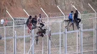 Inmigrantes africanos en la valla fronteriza en Ceuta.