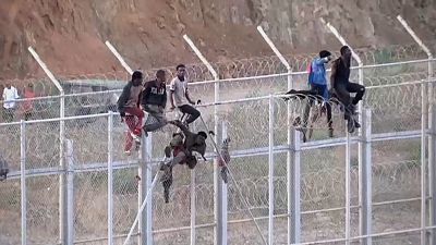 Inmigrantes africanos en la valla fronteriza en Ceuta. 