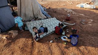 Newly displaced Syrian children play after their arrival to a camp in Idlib