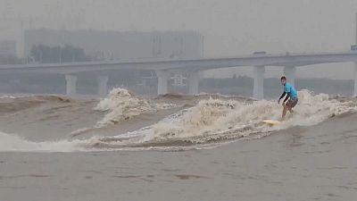 Surfers from around the world gather to ride tidal bores of the Qiantang River