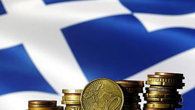 FILE PHOTO: Euro coins are seen in front of a displayed Greece flag in this picture illustration, June 29, 2015. REUTERS/Dado Ruvic/File Photo