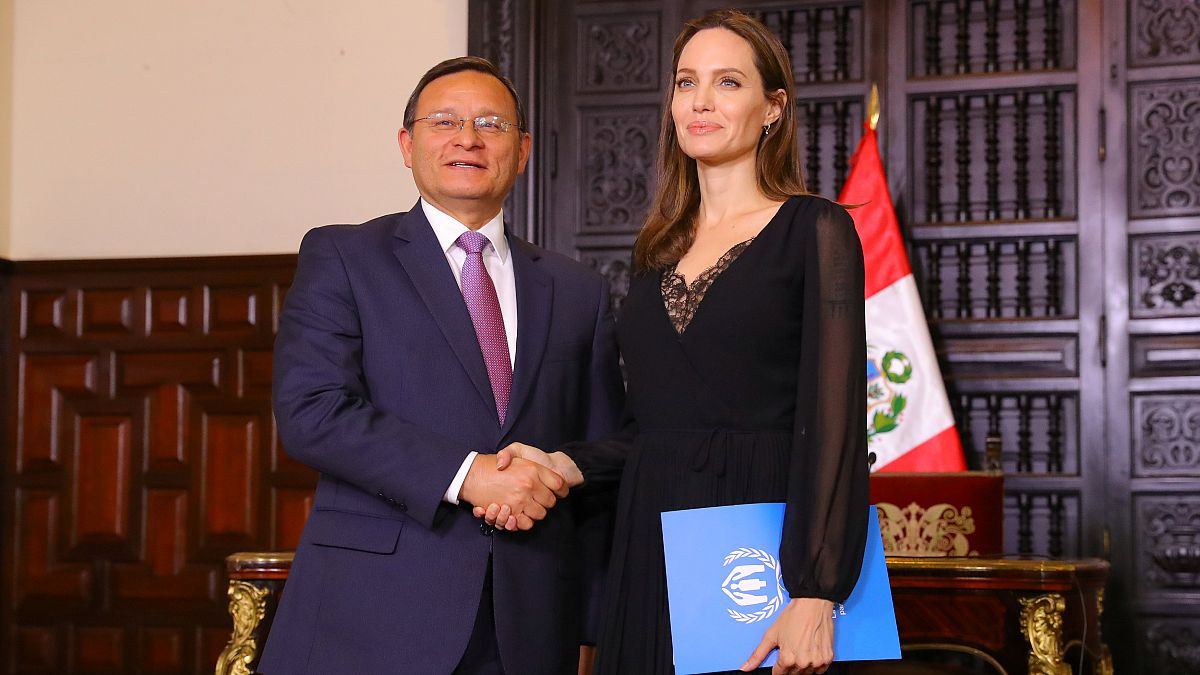 Angelina Jolie und Perus Außenminister Nestor Popolizio schütteln Hände