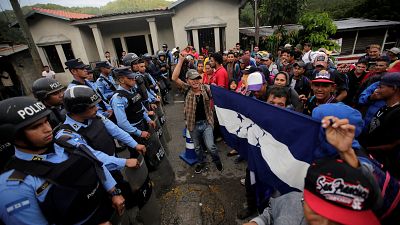 Migrants are confronted by police at the Honduras-Guatemala border