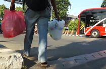 Screencapture showing an Indonesia man bringing plastic bottles to a bus