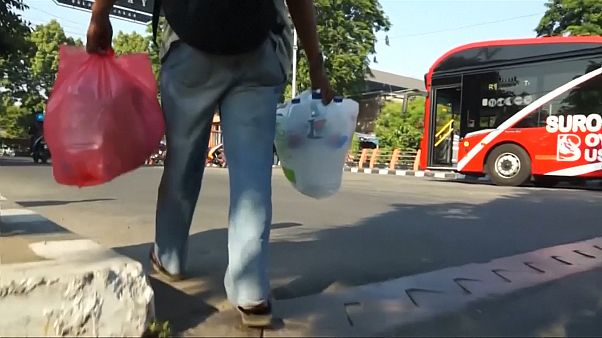 Screencapture showing an Indonesia man bringing plastic bottles to a bus Screencapture showing an Indonesia man bringing plastic bottles to a bus