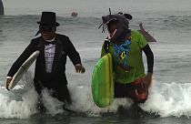 Surfistas disfrazados festejan Halloween sobre las olas en Newport Beach