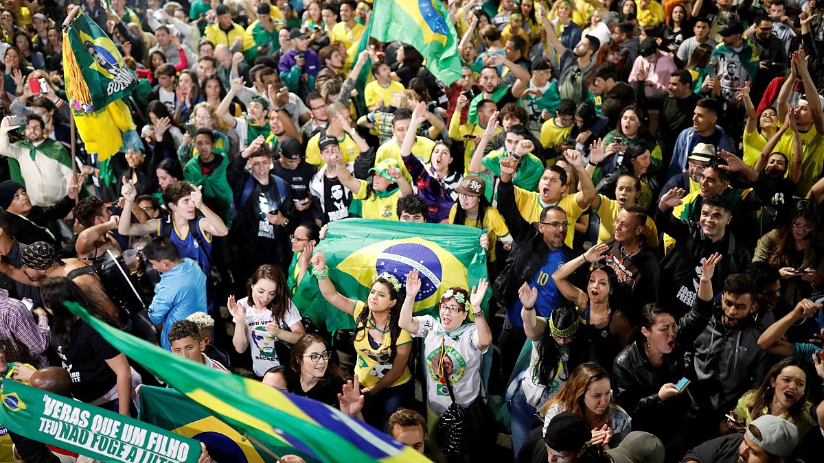 Supporters of Jair Bolsonaro react after Bolsonaro wins the presidential ra