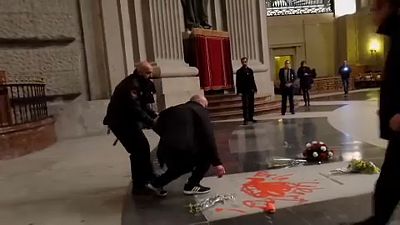 Un artiste peint une colombe rouge sur la tombe de Franco