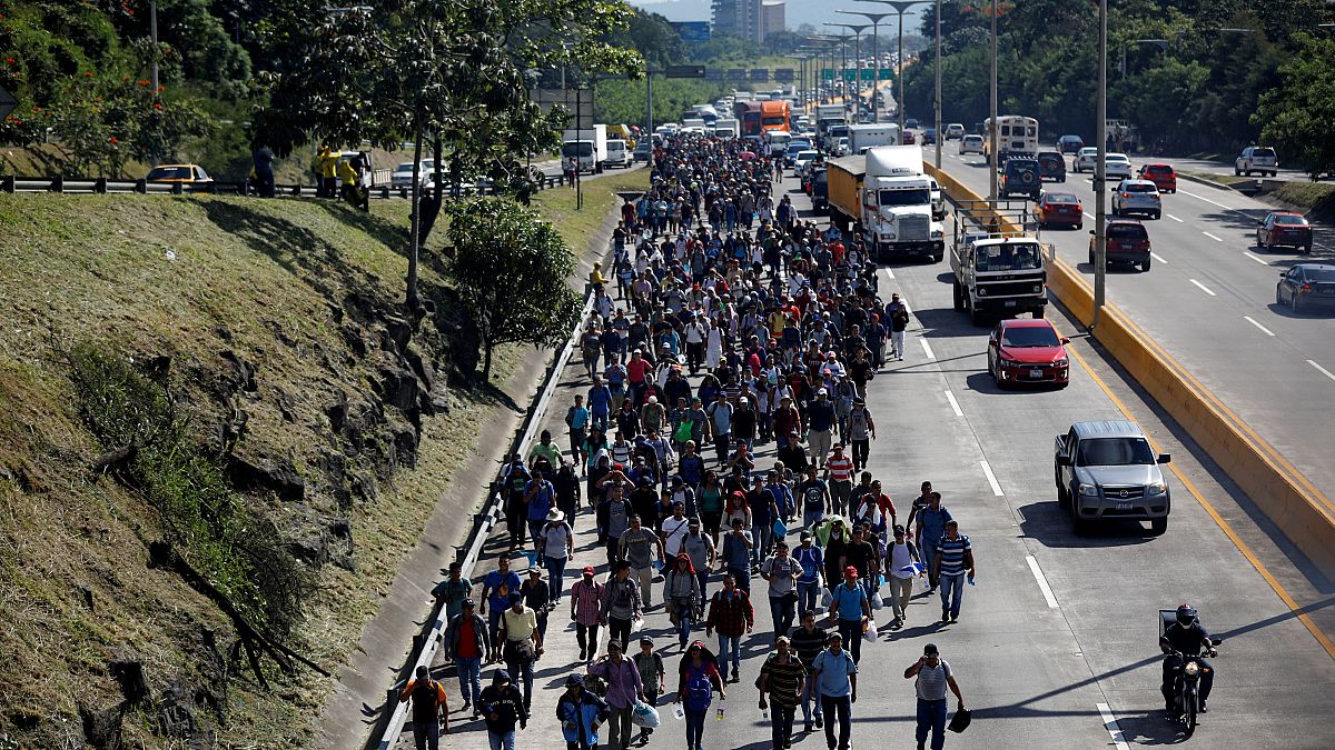 People walk in a caravan of migrants en route to the US in El Salvador.