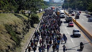 People walk in a caravan of migrants en route to the US in El Salvador.