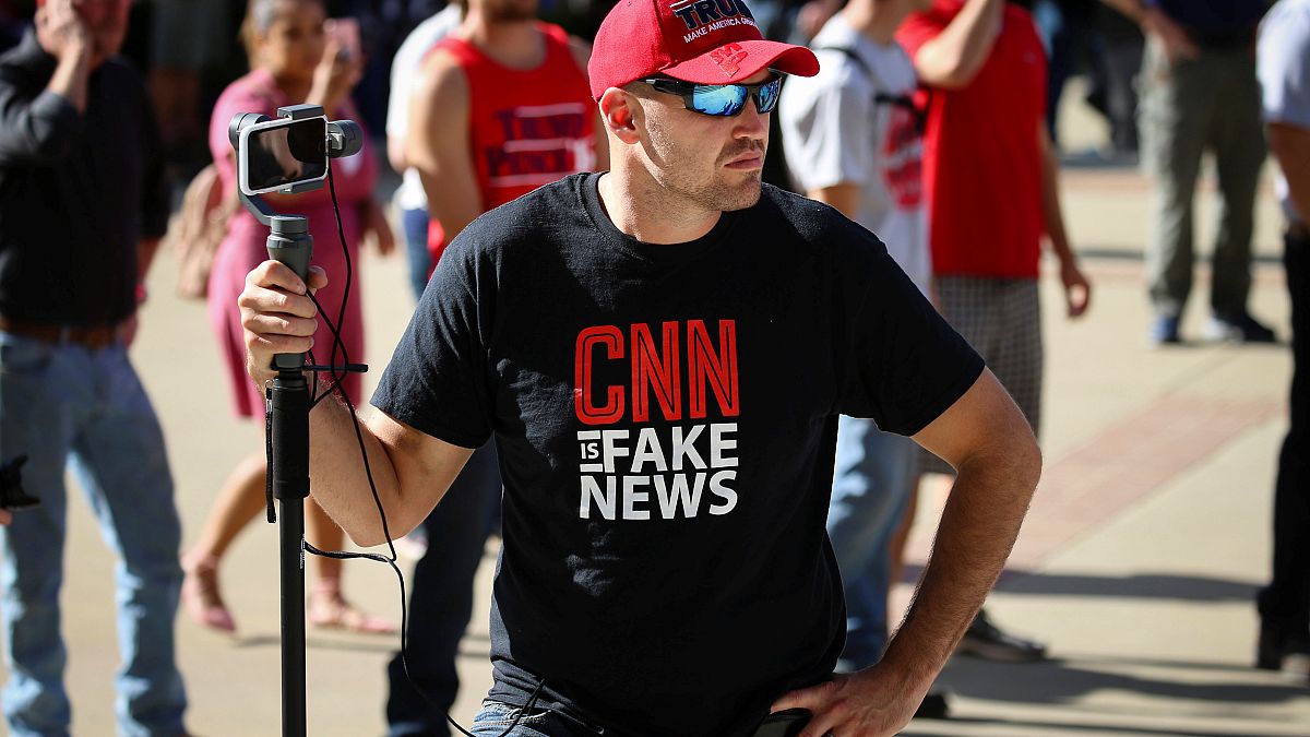 A man wearing a "fake news" T-shirt