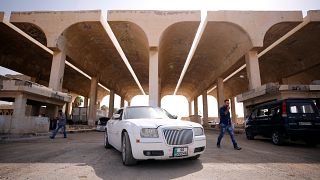 Ein jordanisches weißes Auto steht vorm Grenzübergang