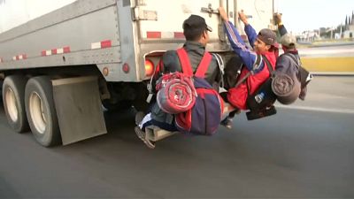 شاهد: آلاف المكسيكيين يتعلقون بظهر الشاحنات على أمل الوصول إلى الحدود الأميركية