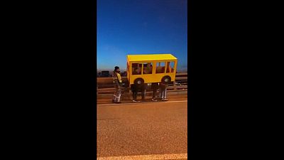 شاهد: شباب يتنكرون بزي حافلة ليتمكنوا من عبور جسر محظور على المشاة في روسيا