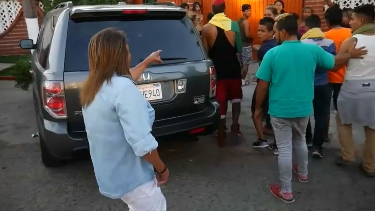 Una vecina de Tijuana señala a los migrantes de la caravana LGTB. 