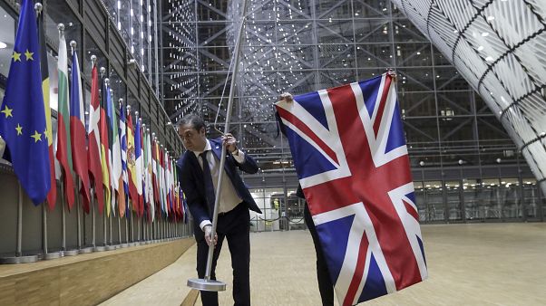 Members of protocol remove the Union flag from the atrium of the Europa building in Brussels, Friday, Jan. 31, 2020. Members of protocol remove the Union flag from the atrium of the Europa building in Brussels, Friday, Jan. 31, 2020.