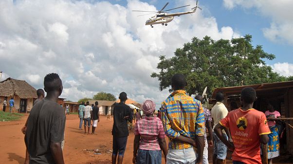 Residents look at a police helicopter patrolling the area Residents look at a police helicopter patrolling the area