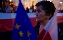 Woman holds flags during an anti-government protest in Warsaw