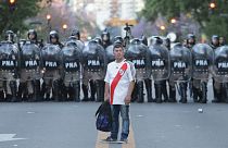 Adepto do River Plate diante de um cordão da polícia argentina