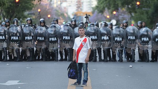 Adepto do River Plate diante de um cordão da polícia argentina Adepto do River Plate diante de um cordão da polícia argentina