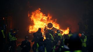 Égő autó a december elsejei párizsi zavargásba torkolló demonstráción