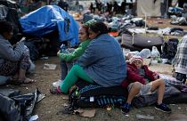 Migrantes esperan a ser trasladados a un nuevo refugio en Tijuana.