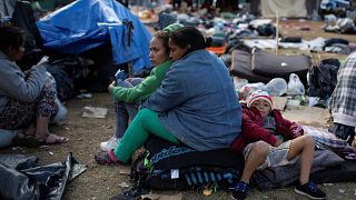 Migrantes esperan a ser trasladados a un nuevo refugio en Tijuana.