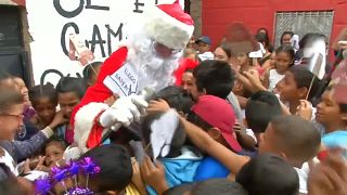 سانتا كلوز في كاراكاس الفنزويلية حاملا الهدايا والمواد الغذائية للمحتاجين