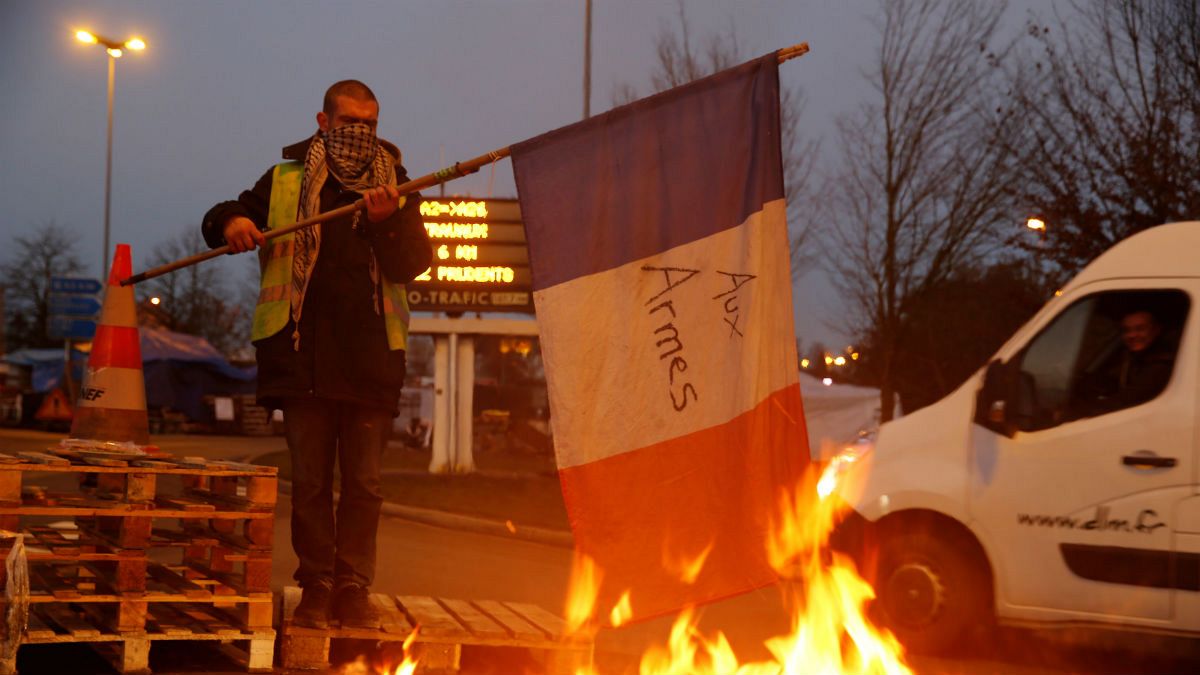 Manifestante dos "coletes amarelos" parece pegar fogo à bandeira francesa