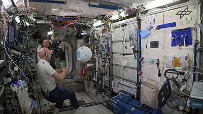Astronaut interacts with robot aboard ISS