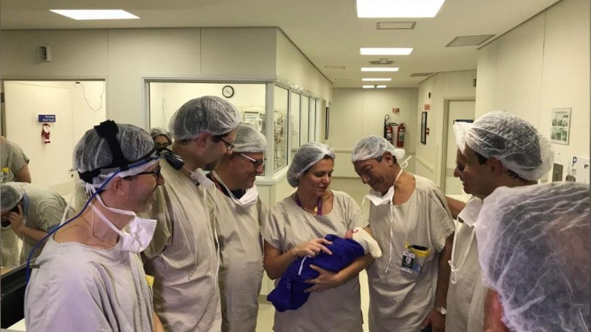 Medical team hold the first baby born via uterus transplant 