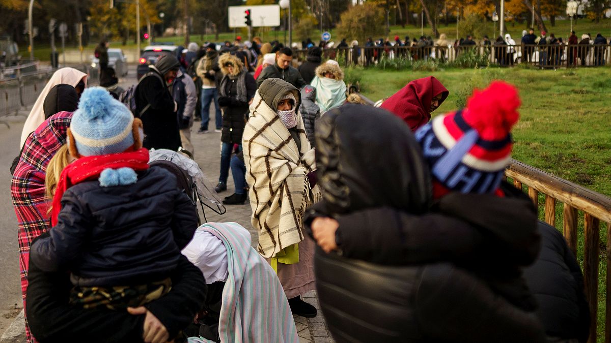 People queue to request asylum outside a Spanish police station on Nov 22