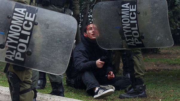 Ein verletzter Demonstrant wird von griechischen Polizisten festgehalten. Ein verletzter Demonstrant wird von griechischen Polizisten festgehalten.