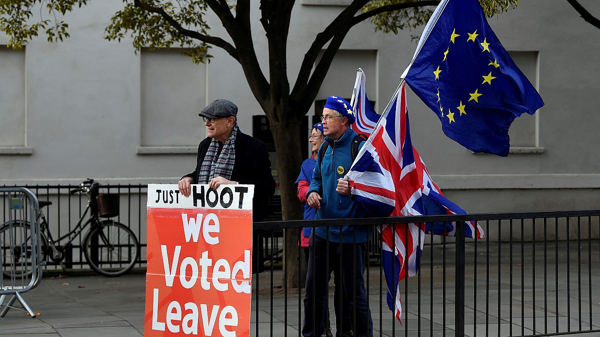 Pro-Brexit and anti-Brexit protesters hold posters and flags in Whitehall