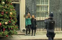 Two women get lots of photos infront of 10 Downing St. 