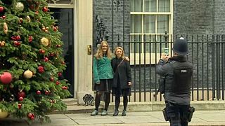 Two women get lots of photos infront of 10 Downing St. 