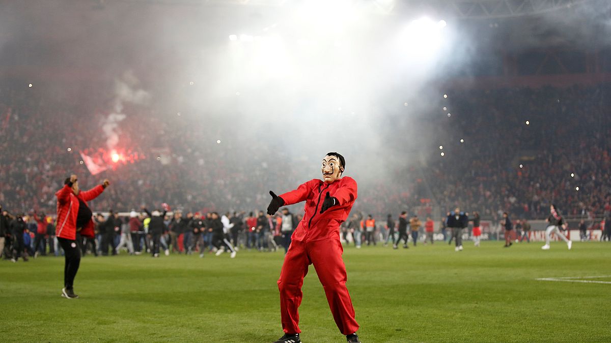 An Olympiacos FC fan celebrating the club's win against Milan