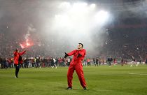 An Olympiacos FC fan celebrating the club's win against Milan