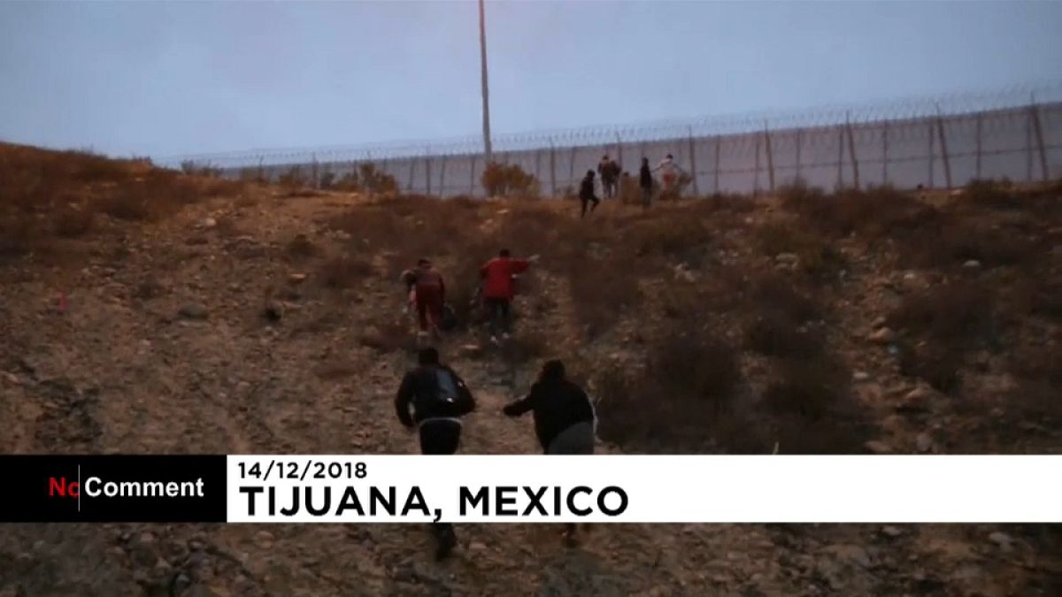 عائلة مهاجرين من أمريكا الوسطى يجتازون السياج بين المكسيك والولايات المتحدة