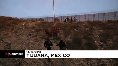عائلة مهاجرين من أمريكا الوسطى يجتازون السياج بين المكسيك والولايات المتحدة