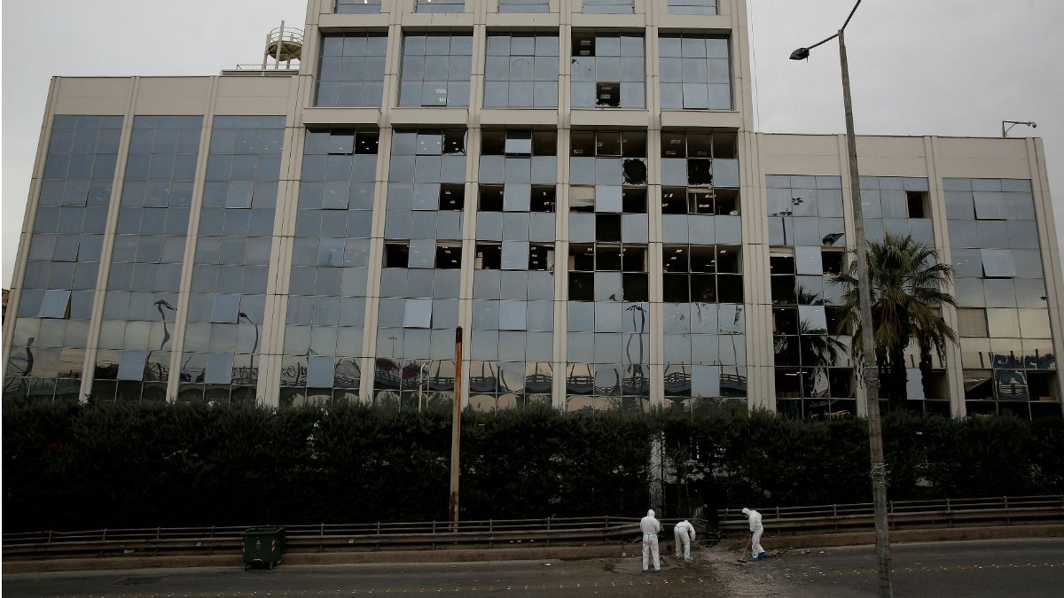 Investigadores forenses recolhem vestígios diante do edifício da Skai TV