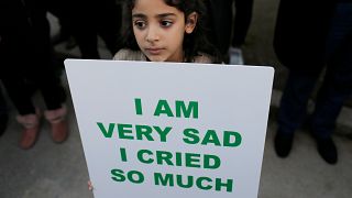 A girl in Morocco holds sign in front of Denmark's embassy in Rabat