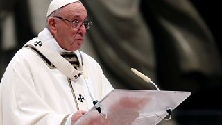 Pope Francis carries a statue of Baby Jesus during the Christmas Eve mass