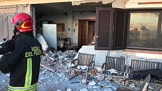 Firefighters attend a damaged building after an earthquake on Dec 26, 2018