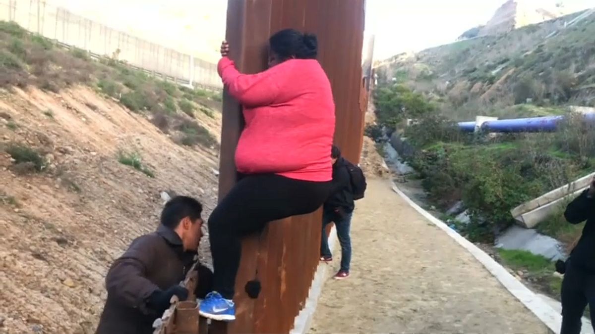شاهد: مهاجرون يتسلقون السياج الحدودي في المكسيك للعبور إلى الولايات المتحدة