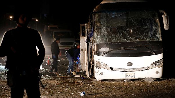 Police officers inspect a scene of a bus blast in Giza Police officers inspect a scene of a bus blast in Giza